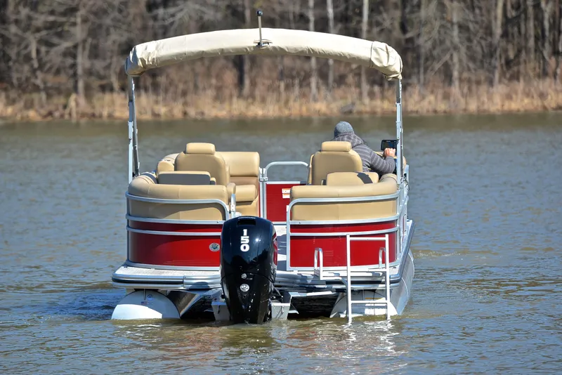 Slide: The Image of 2021 Lowe SS250 pontoon boat cruising on a calm lake. - 7