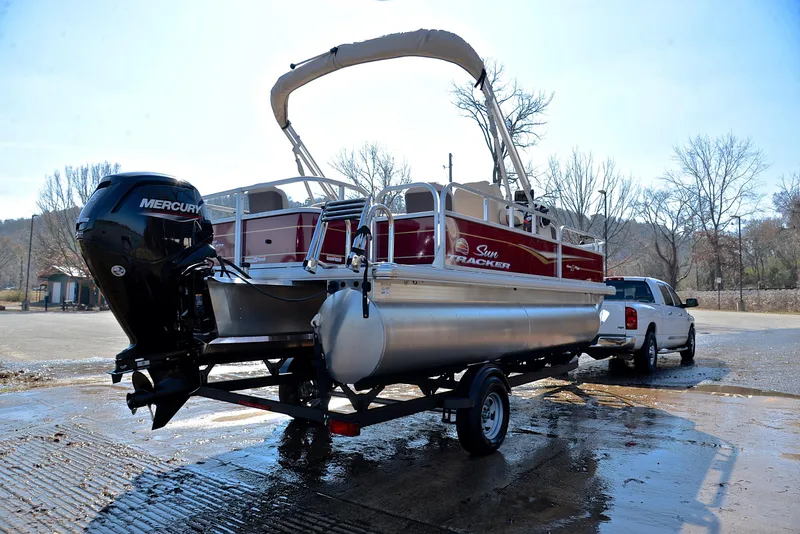 Slide: The Image of 2024 Sun Tracker BASS BUGGY 18 pontoon boat on trailer, ready for launch. - 14