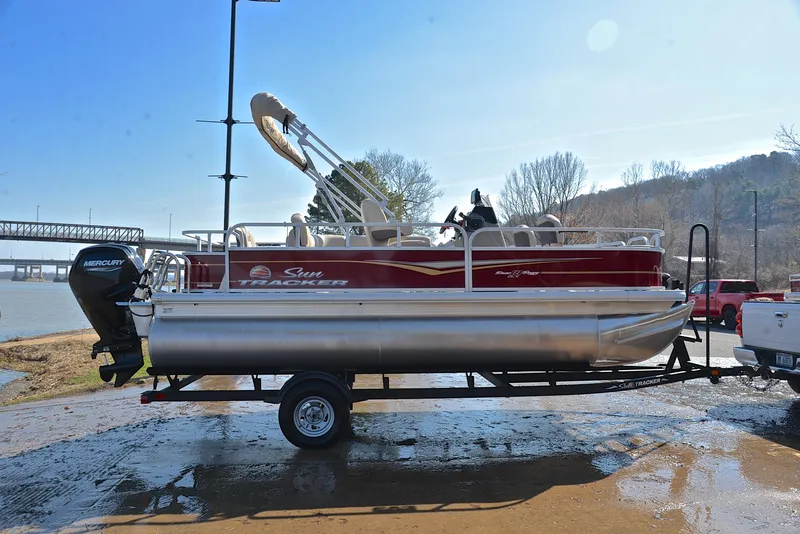Slide: The Image of 2024 Sun Tracker BASS BUGGY 18 pontoon boat on trailer by riverside. - 15