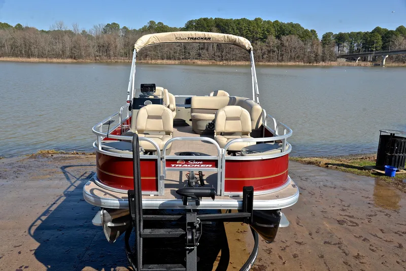 Slide: The Image of 2024 Sun Tracker BASS BUGGY 18 pontoon boat on a lake shore. - 17