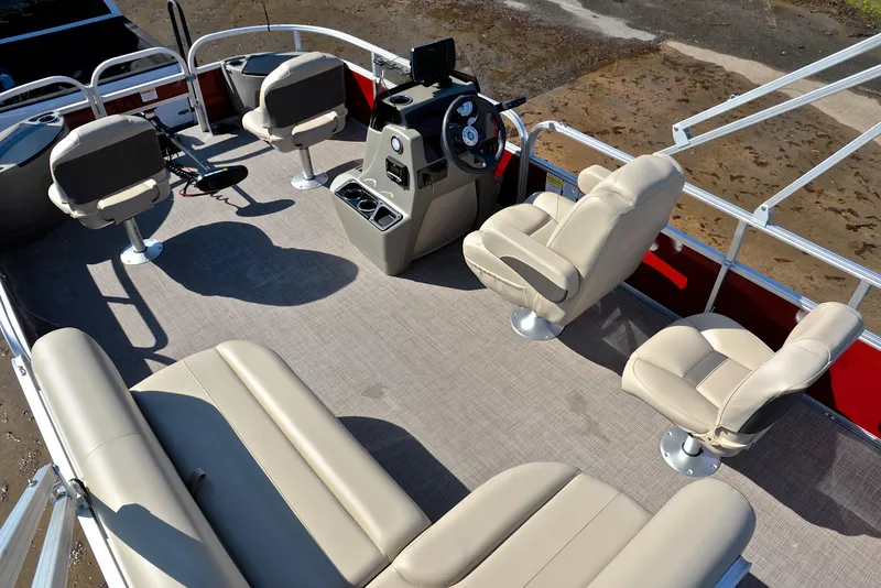 Slide: The Image of 2024 Sun Tracker BASS BUGGY 18 pontoon boat interior with beige seating and steering console. - 20