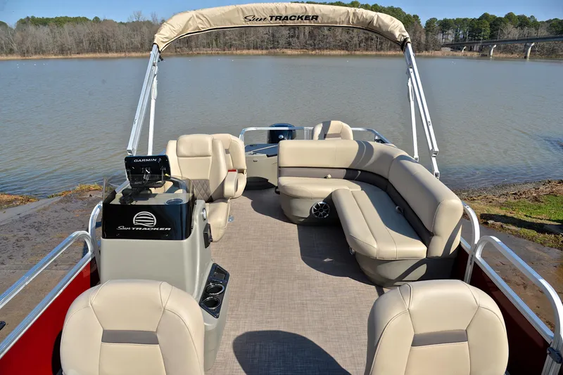 Slide: The Image of 2024 Sun Tracker BASS BUGGY 18 pontoon boat with spacious seating on a calm lake. - 21