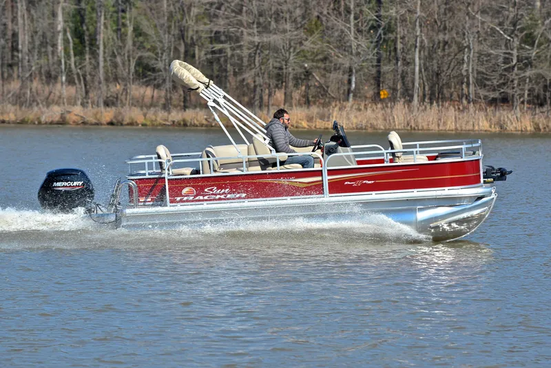 Slide: The Image of 2024 Sun Tracker BASS BUGGY 18 pontoon boat cruising on a lake. - 3