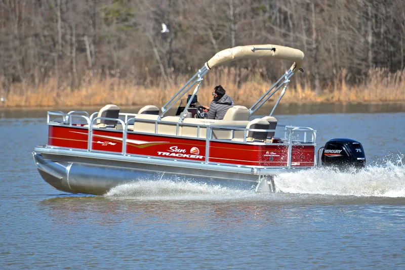 Slide: The Image of 2024 Sun Tracker BASS BUGGY 18 pontoon boat cruising on a lake. - 4