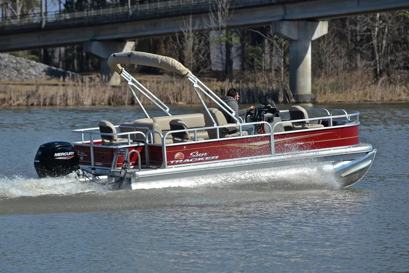Slide: The Image of 2024 Sun Tracker BASS BUGGY 18 pontoon boat cruising on a lake. - 5