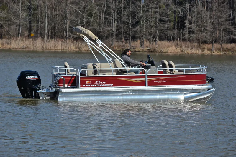Slide: The Image of 2024 Sun Tracker BASS BUGGY 18 pontoon boat cruising on a lake. - 6