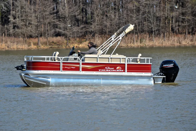 Slide: The Image of 2024 Sun Tracker BASS BUGGY 18 pontoon boat cruising on a lake. - 8
