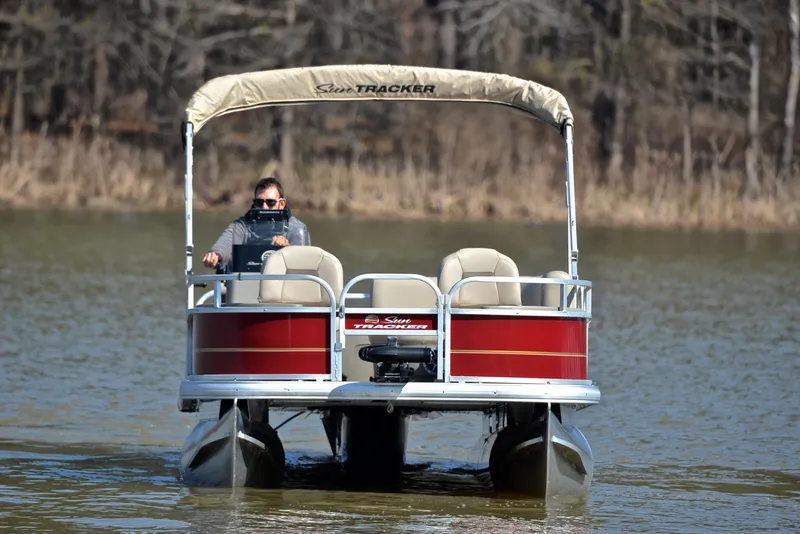 Slide: The Image of 2024 Sun Tracker BASS BUGGY 18 pontoon boat on a calm lake. - 9