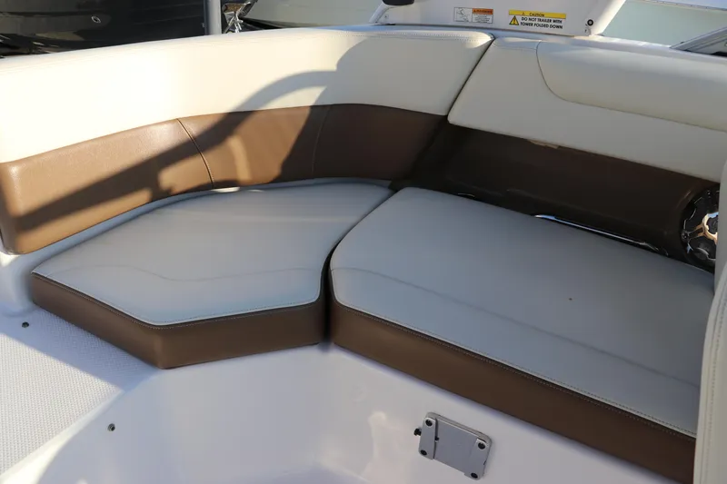 Slide: The Image of 2018 Chaparral 230 Suncoast boat interior seating with brown and white upholstery. - 10