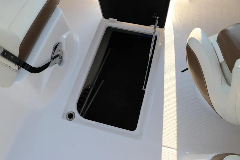 Slide: The Image of 2018 Chaparral 230 Suncoast boat interior storage compartment, open with seating visible. - 16