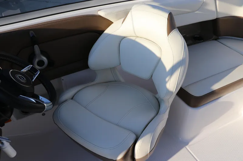 Slide: The Image of 2018 Chaparral 230 Suncoast boat interior with white captain's chair and steering wheel. - 22