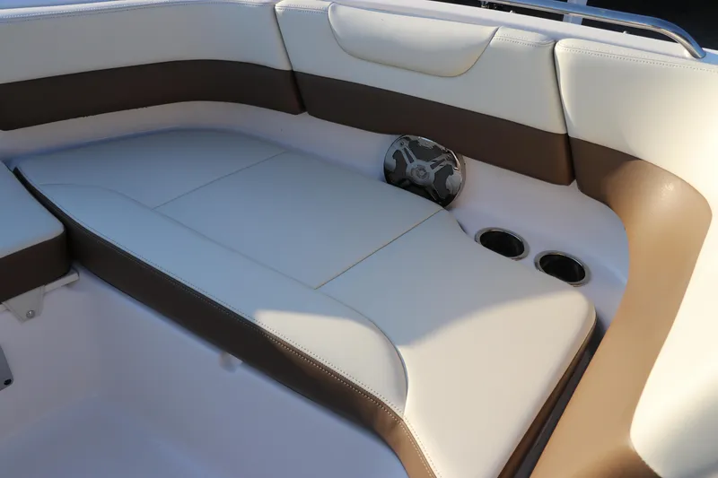 Slide: The Image of 2018 Chaparral 230 Suncoast boat interior with cushioned seating and cup holders. - 33