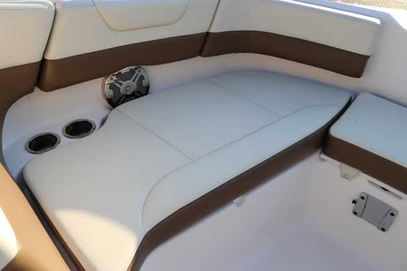 Slide: The Image of 2018 Chaparral 230 Suncoast boat interior with cushioned seating and cup holders. - 37