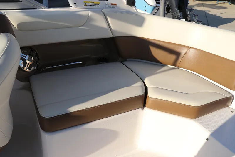 Slide: The Image of 2018 Chaparral 230 Suncoast boat interior seating with beige and brown cushions. - 9