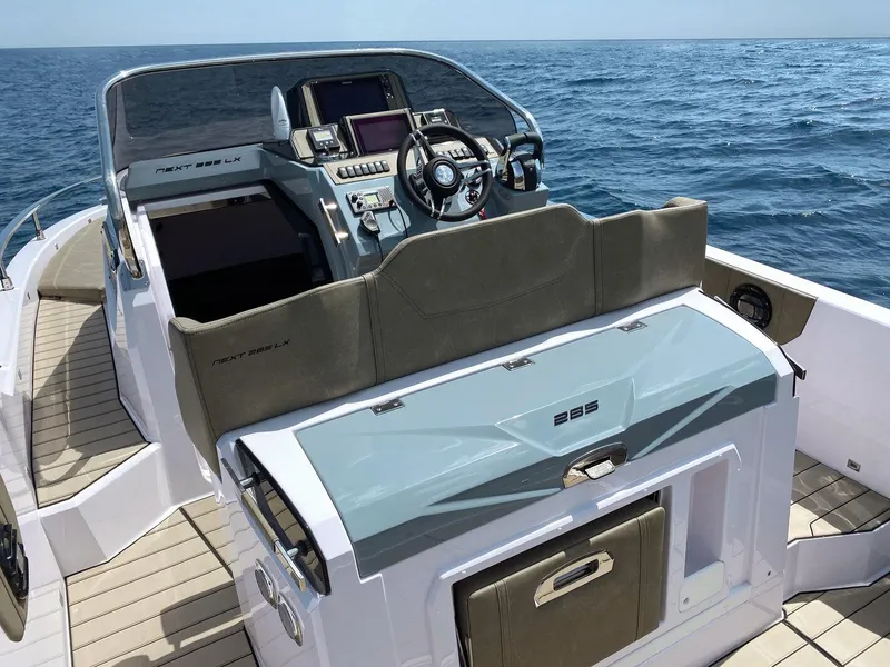 Slide: The Image of 2025 Ranieri NEXT 285 XL boat cockpit with modern controls, steering wheel, and ocean view. - 21