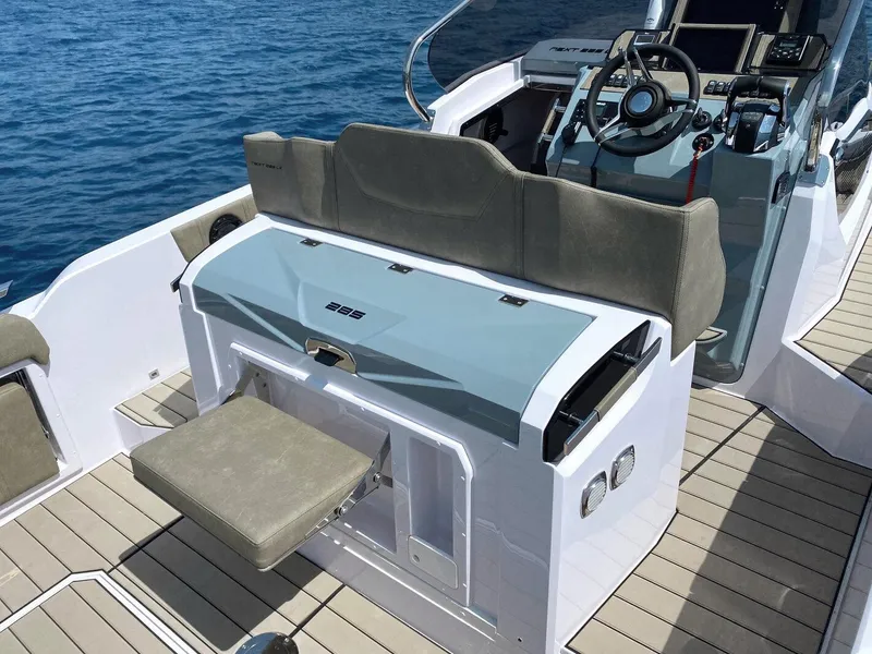 Slide: The Image of 2025 Ranieri NEXT 285 XL boat interior with seating and steering console on open water. - 23