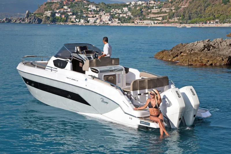 Slide: The Image of 2025 Ranieri NEXT 285 XL boat cruising near scenic coastline. - 8