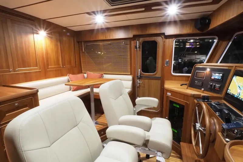 Slide: The Image of Luxurious interior of 2025 Helmsman Trawlers 46 Pilothouse with wood finish and modern controls. - 11