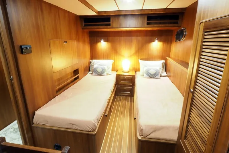 Slide: The Image of 2025 Helmsman Trawlers 46 Pilothouse cabin with twin beds and warm wood interior. - 23