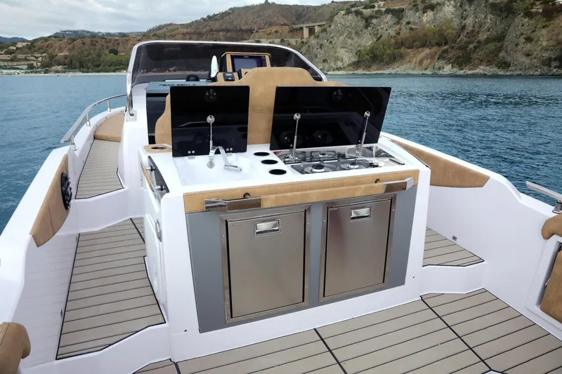 Slide: The Image of 2025 Ranieri NEXT 330 XL yacht with outdoor kitchen on deck, cruising near scenic coastline. - 6