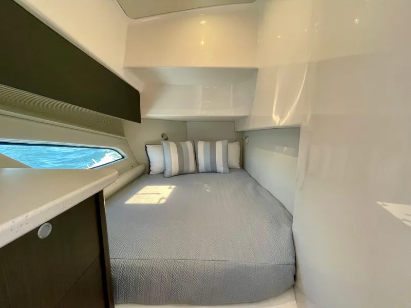 Slide: The Image of 2022 Intrepid 477 Evolution cabin with bed, pillows, and window view. - 12