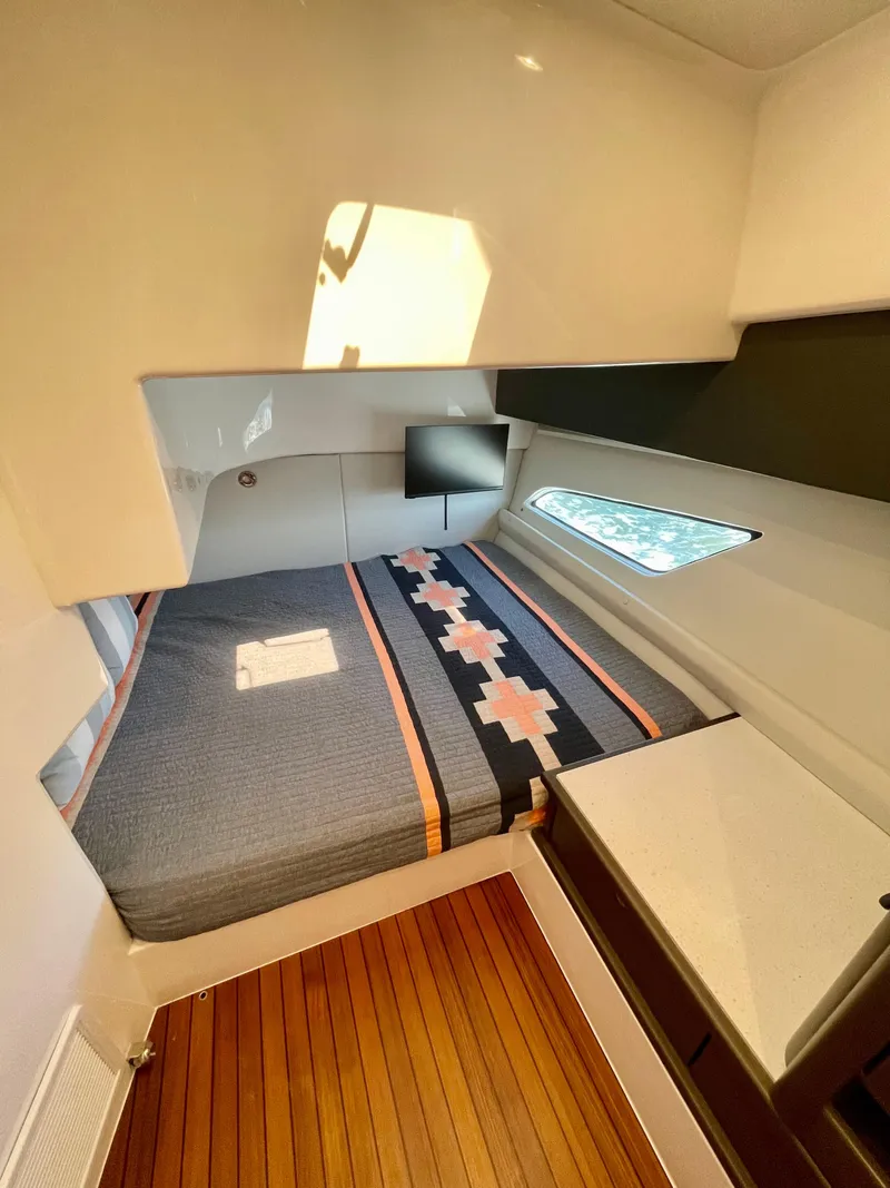 Slide: The Image of 2022 Intrepid 477 Evolution cabin interior with bed, wooden flooring, and window. - 13