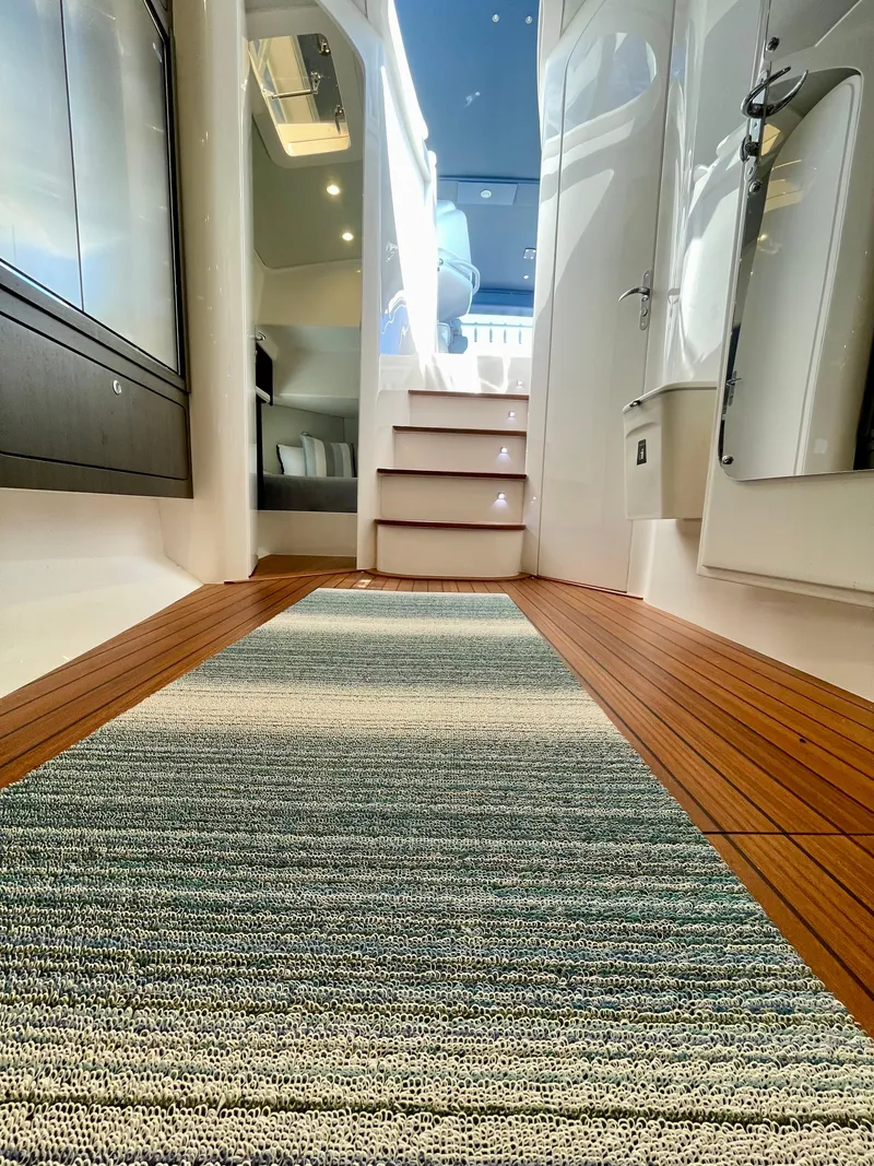 Slide: The Image of Interior view of 2022 Intrepid 477 Evolution yacht, featuring wooden flooring and modern design. - 14