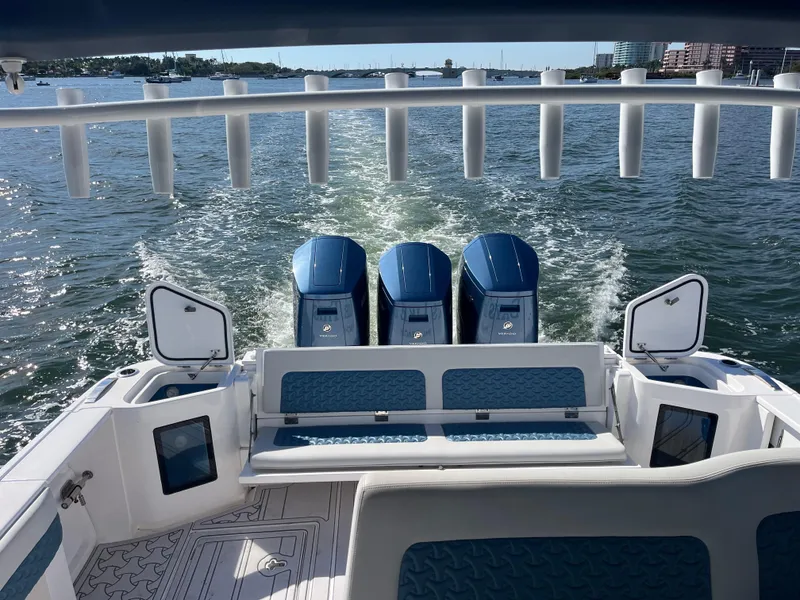 Slide: The Image of 2022 Intrepid 477 Evolution boat with triple outboard engines cruising on water. - 6