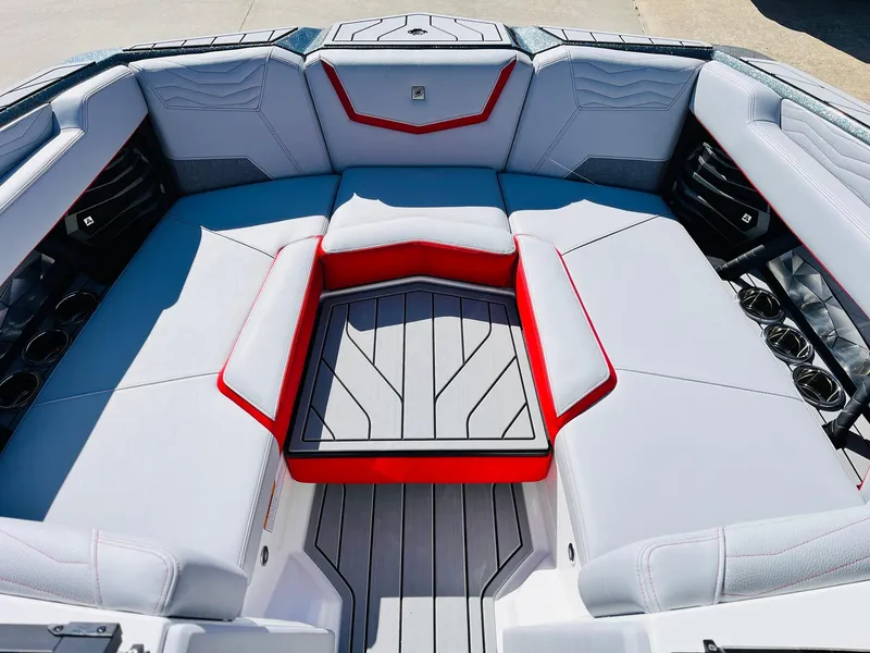 Slide: The Image of 2025 Nautique Super Air Nautique G23 interior with gray and red seating, cup holders, and sleek design. - 15