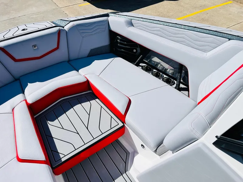 Slide: The Image of 2025 Nautique Super Air Nautique G23 interior with sleek gray and red seating design. - 16