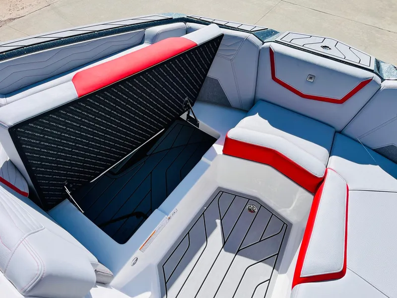 Slide: The Image of 2025 Nautique Super Air Nautique G23 interior with red and gray seating and storage compartment. - 17