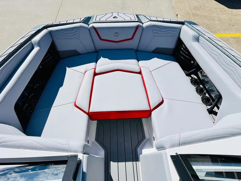 Slide: The Image of 2025 Nautique Super Air Nautique G23 boat interior with gray and red seating. - 20