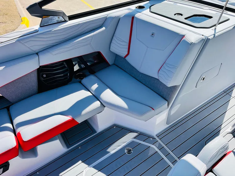 Slide: The Image of 2025 Nautique Super Air Nautique G23 interior with sleek gray and red seating design. - 24