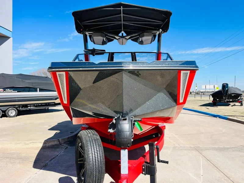 Slide: The Image of 2025 Nautique Super Air Nautique G23 boat, red and black, on trailer, front view. - 3