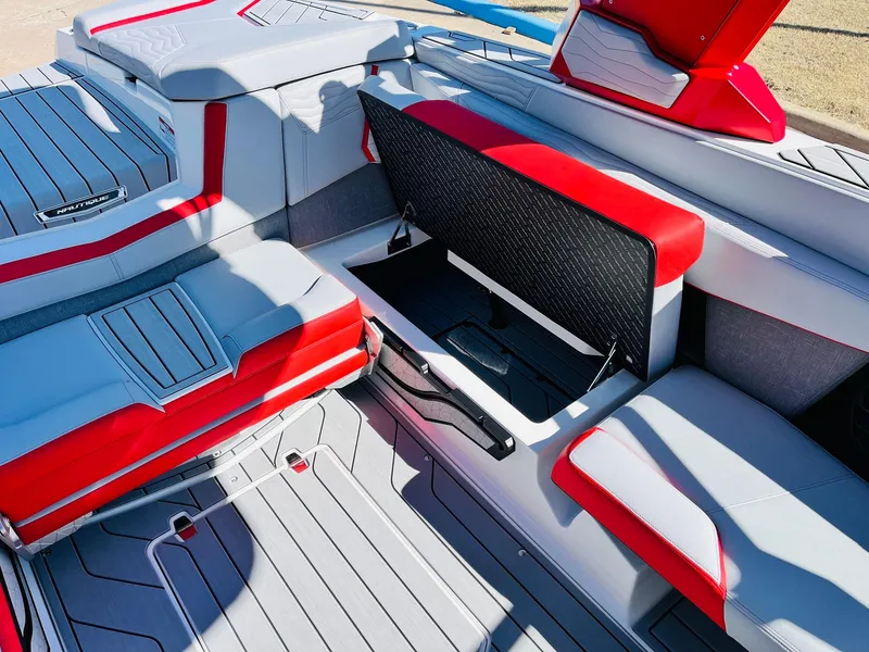Slide: The Image of 2025 Nautique Super Air Nautique G23 interior with red and gray seating and storage compartment. - 30