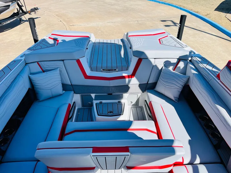 Slide: The Image of 2025 Nautique Super Air Nautique G23 boat interior with modern seating and red accents. - 34