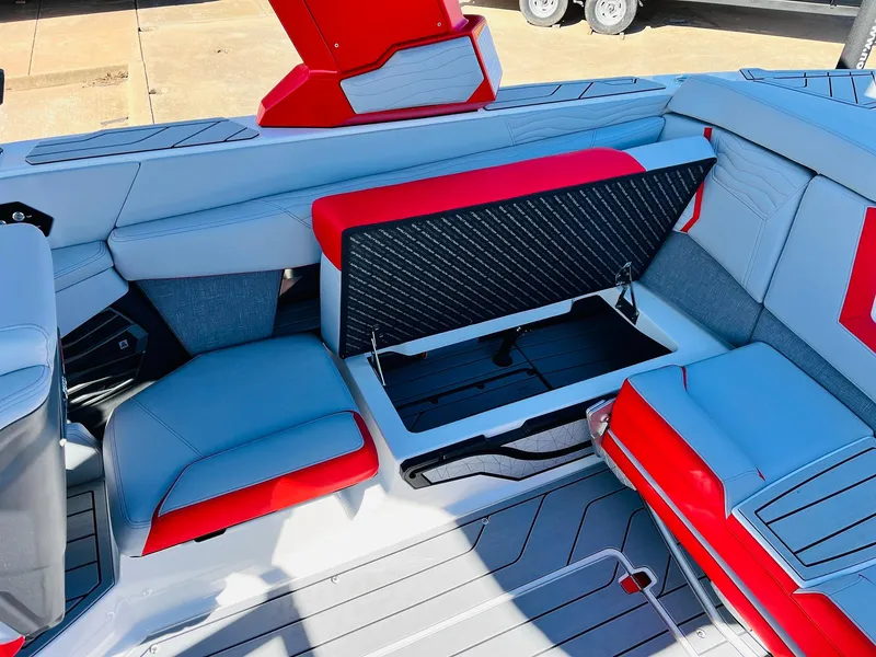 Slide: The Image of 2025 Nautique Super Air Nautique G23 interior with open storage compartment, red and gray seating. - 40