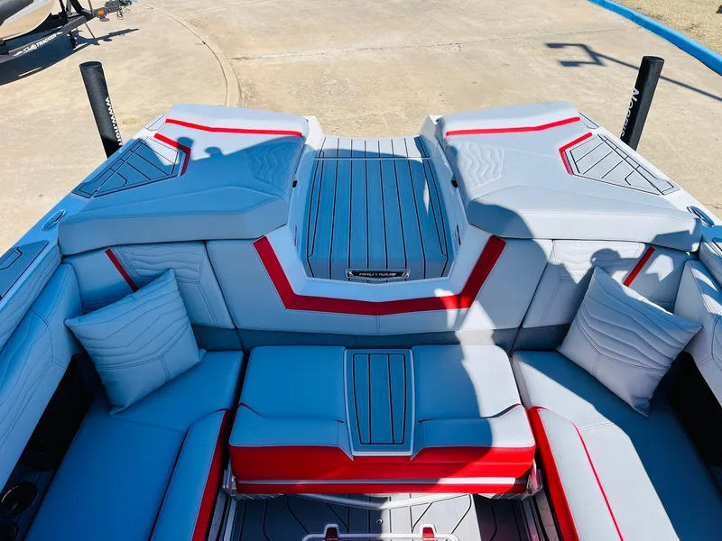 Slide: The Image of 2025 Nautique Super Air Nautique G23 boat interior with red and gray seating. - 48
