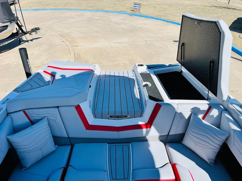 Slide: The Image of 2025 Nautique Super Air Nautique G23 interior with open storage, red accents, and cushioned seating. - 49