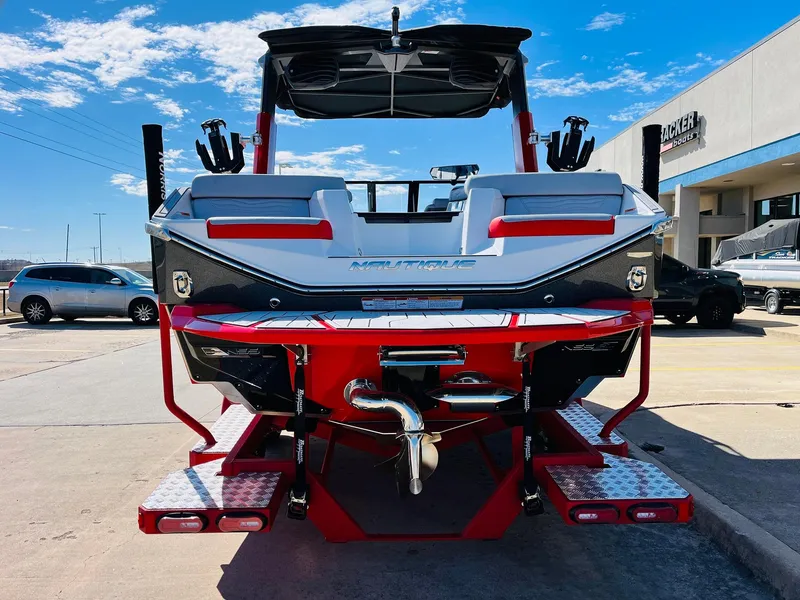Slide: The Image of 2025 Nautique Super Air Nautique G23 boat, rear view, in a parking lot. - 7