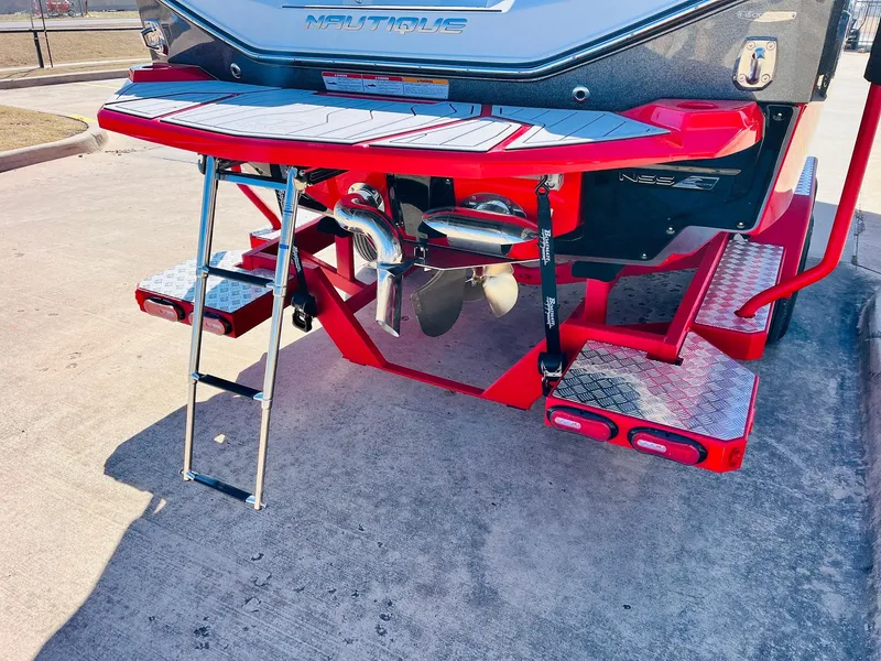 Slide: The Image of 2025 Nautique Super Air Nautique G23 rear view with red platform and ladder. - 9