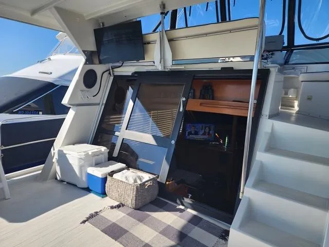 Slide: The Image of 1988 President 37 Sundeck yacht interior with TV, storage, and stairs. - 12