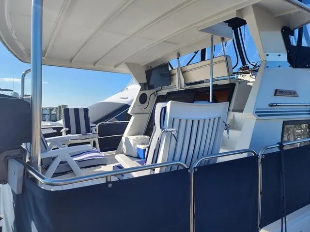 Slide: The Image of 1988 President 37 Sundeck yacht with striped seating and spacious deck area. - 13