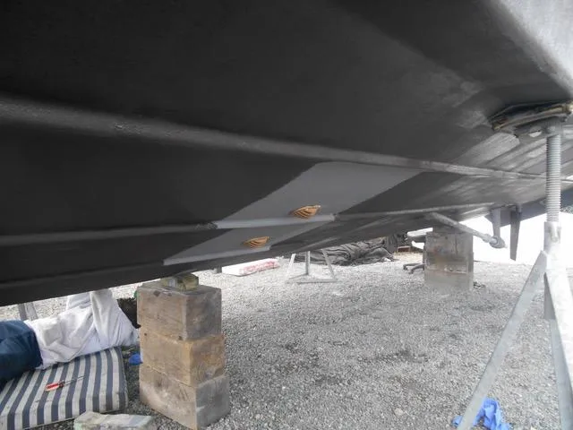 Slide: The Image of 1988 President 37 Sundeck with striped chairs, docked at a marina with blue buildings. - 16