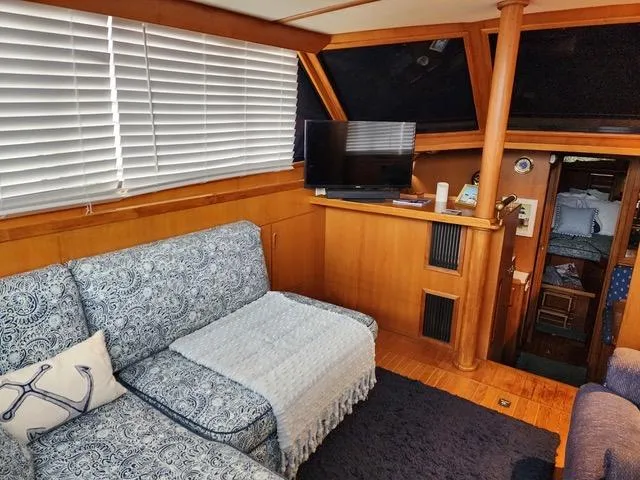 Slide: The Image of 1988 President 37 Sundeck boat hull on supports, undergoing maintenance on gravel surface. - 23