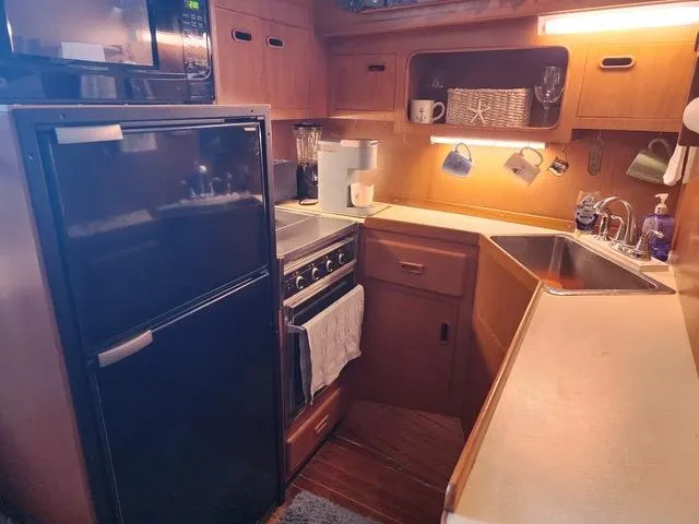 Slide: The Image of 1988 President 37 Sundeck yacht interior with blue anchor-patterned seating and wooden dining table. - 36