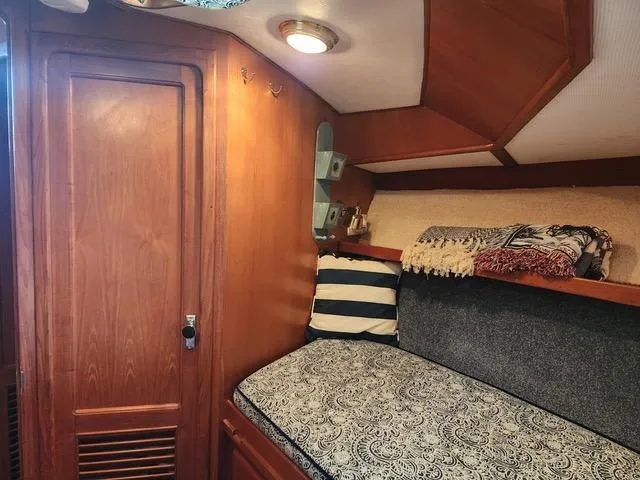 Slide: The Image of 1988 President 37 Sundeck cabin interior with cozy bed and wooden cabinetry. - 57