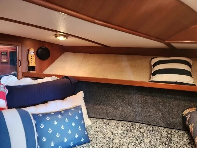 Slide: The Image of Cozy cabin interior of 1988 President 37 Sundeck with nautical-themed pillows. - 58