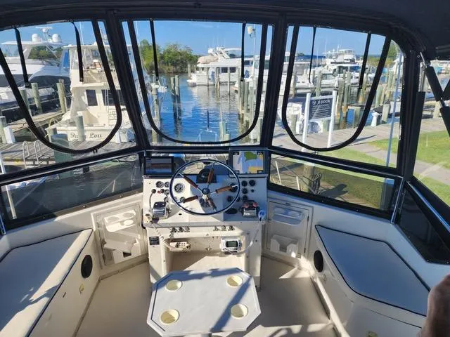 Slide: The Image of 1988 President 37 Sundeck yacht helm with marina view, featuring steering wheel and control panel. - 8