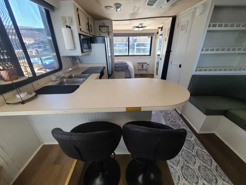 Slide: The Image of Modern kitchen interior in a 1993 Gibson SPORT SERIES boat, featuring a breakfast bar and seating. - 13